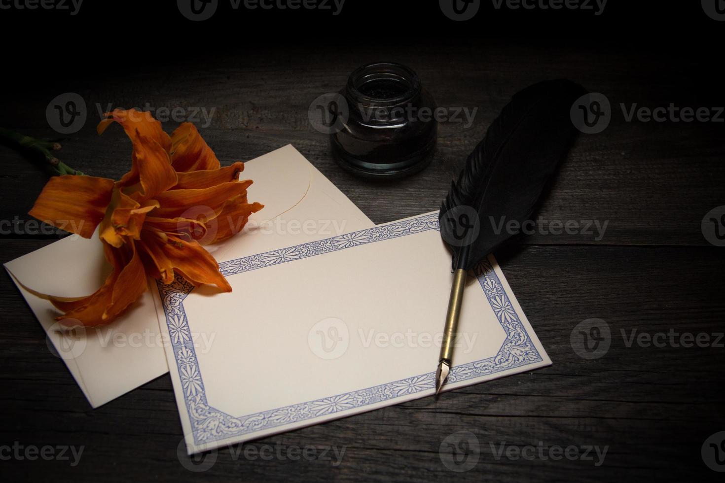 A sheet of old paper with a pen and a flower photo