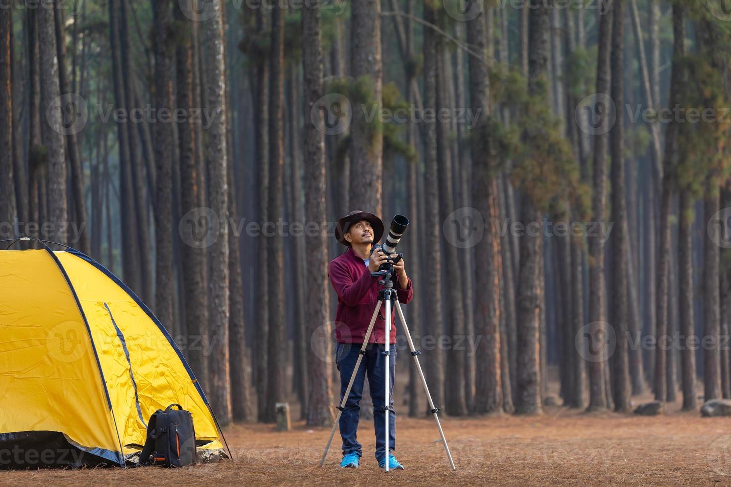 Asian naturalist looking at the new discovering bird species while exploring in the pine forest at campsite for surveying and locating the rare biological diversity and ecologist on the field study photo