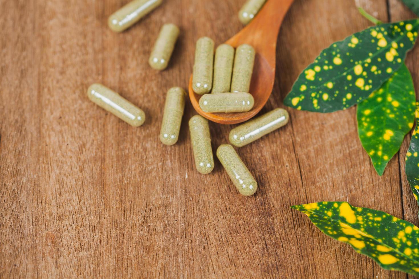 Herbal medicine capsules from herb on rustic wooden table for healthy eating and good life ,soft focus. photo
