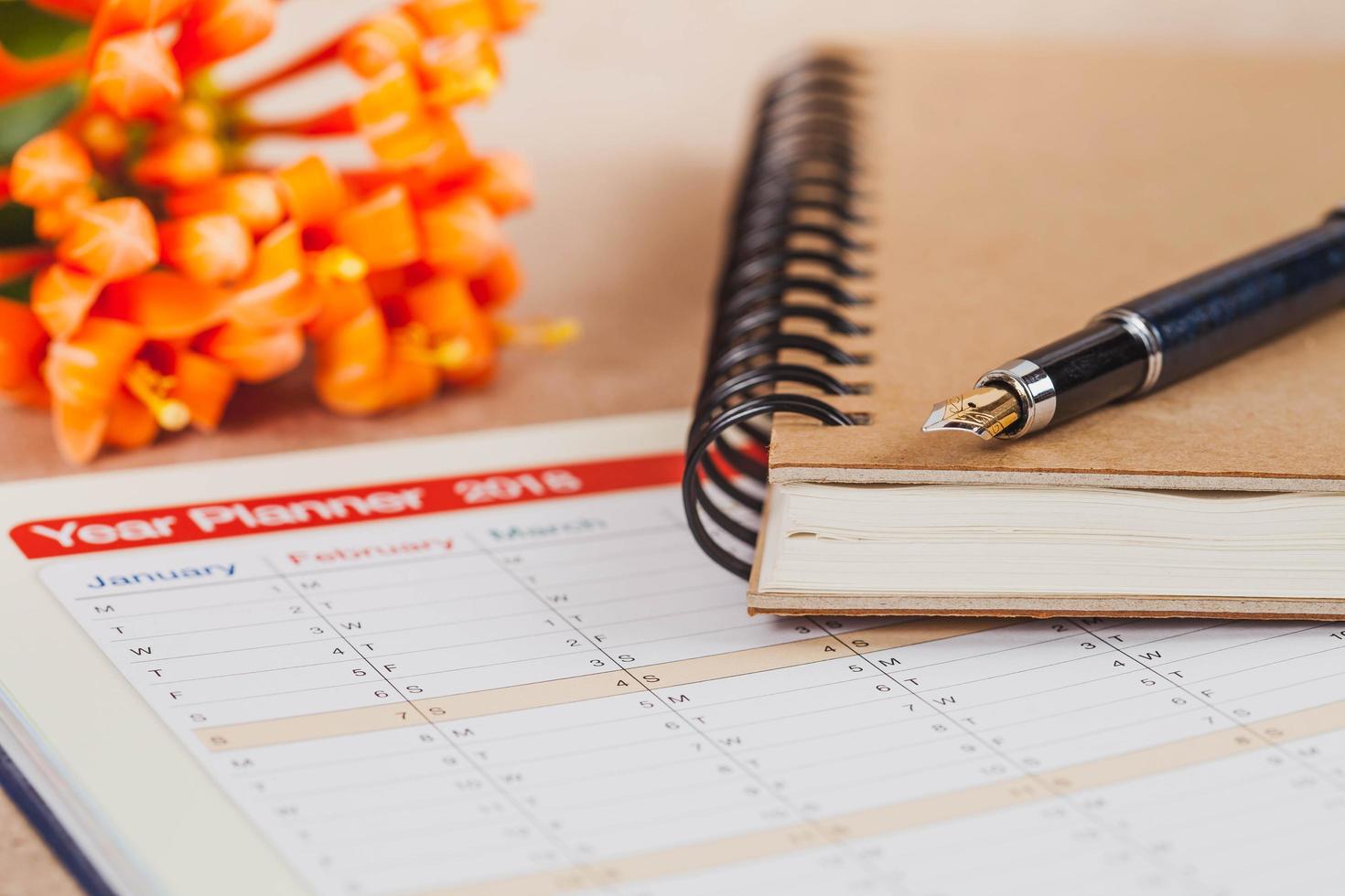 personal organizer or planner with fountain pen on wood table. photo