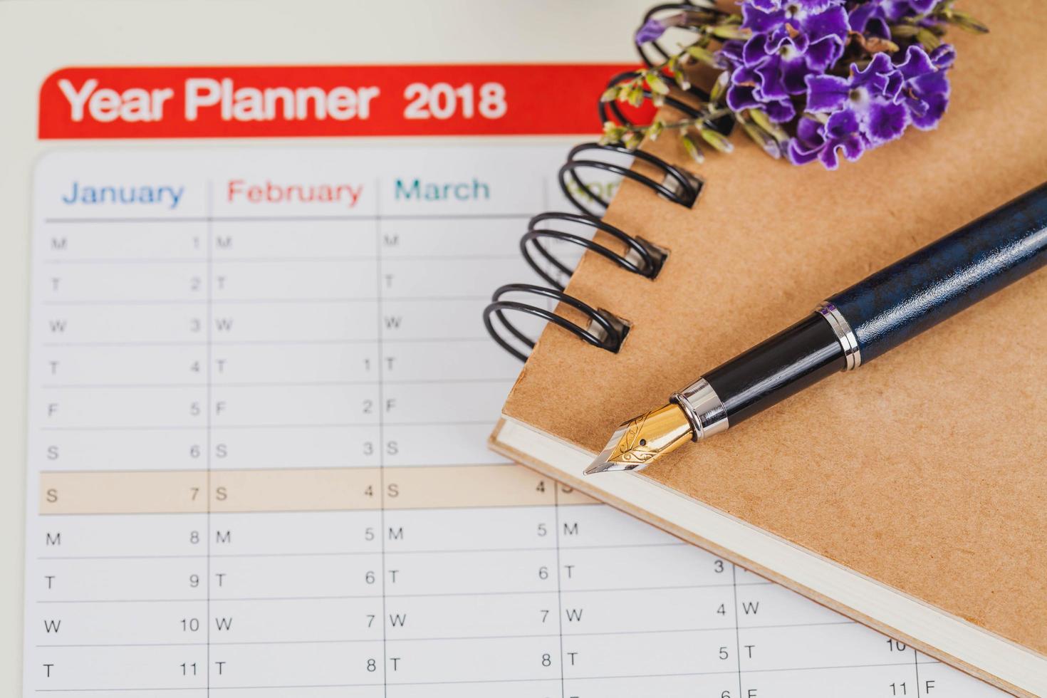 personal organizer or planner with fountain pen on wood table. photo