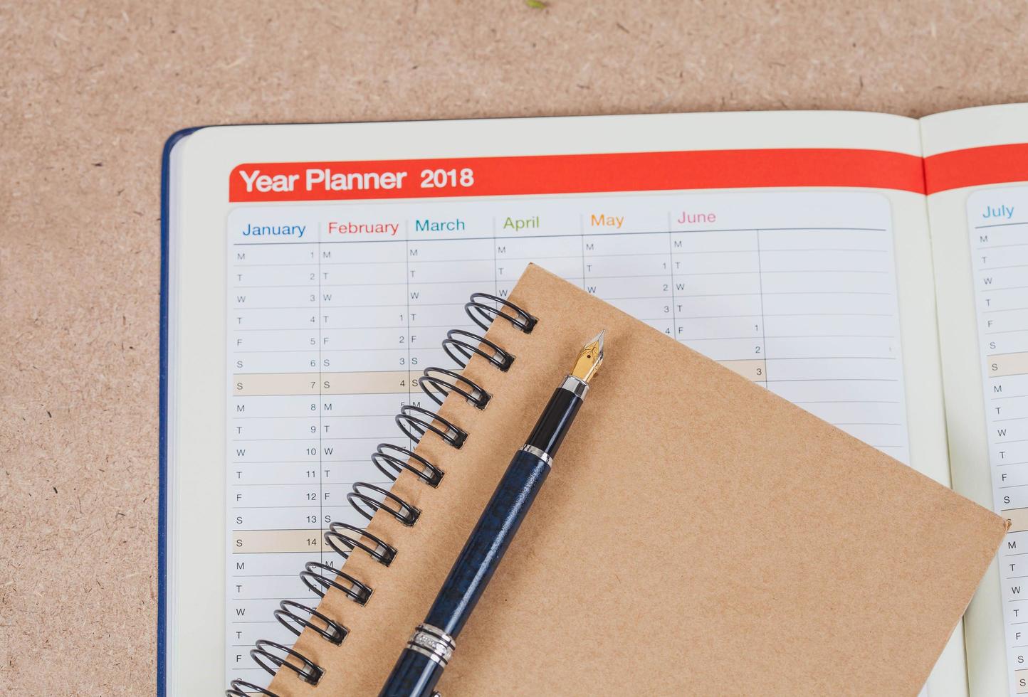 personal organizer or planner with fountain pen on wood table. photo