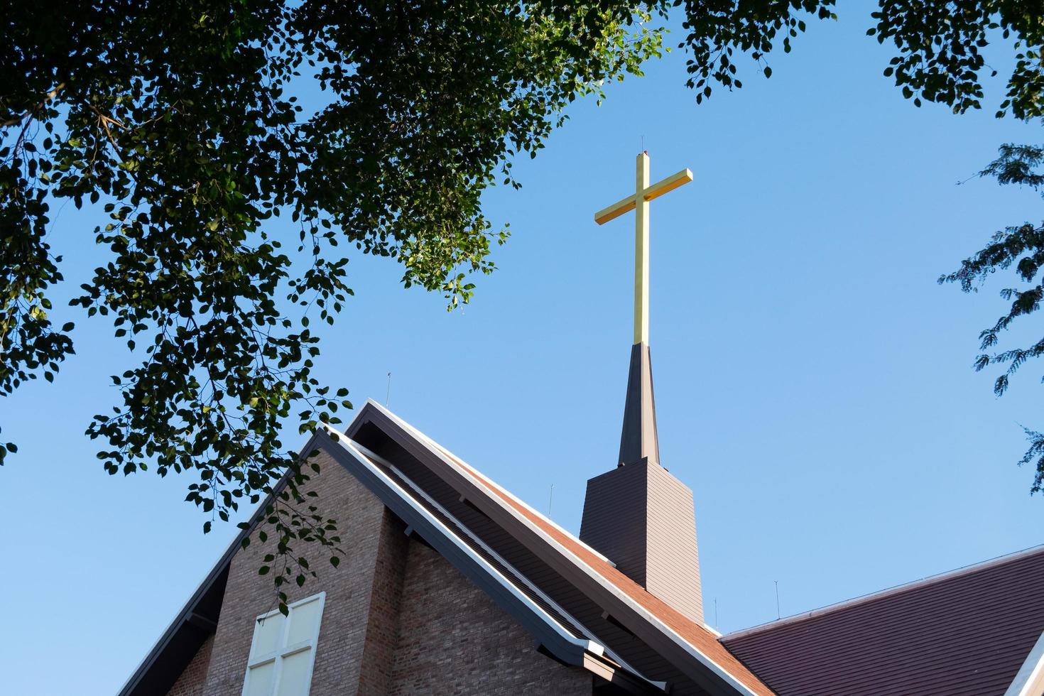 cross on top of roof with a blue sky. photo