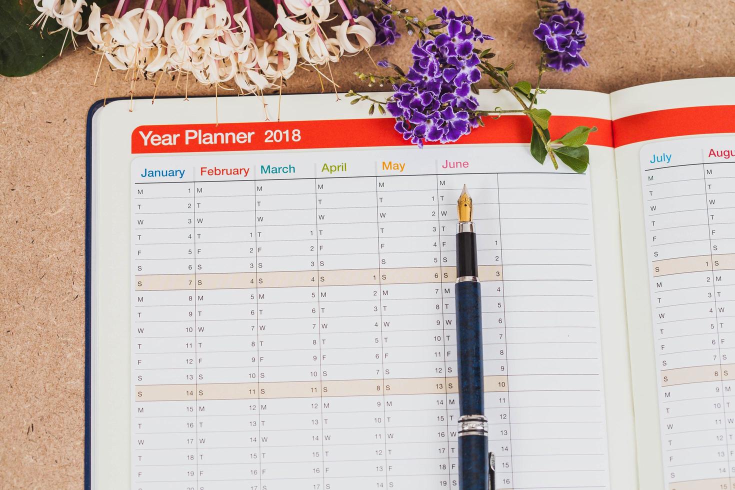personal organizer or planner with fountain pen on wood table. photo