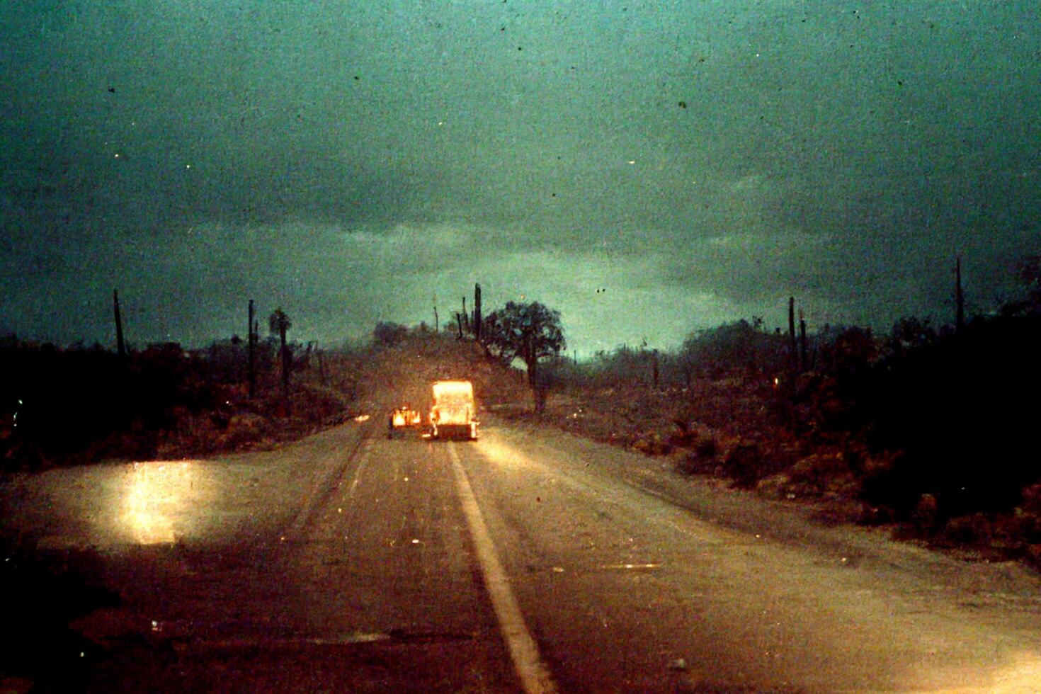 truck driving down a road at night. . photo