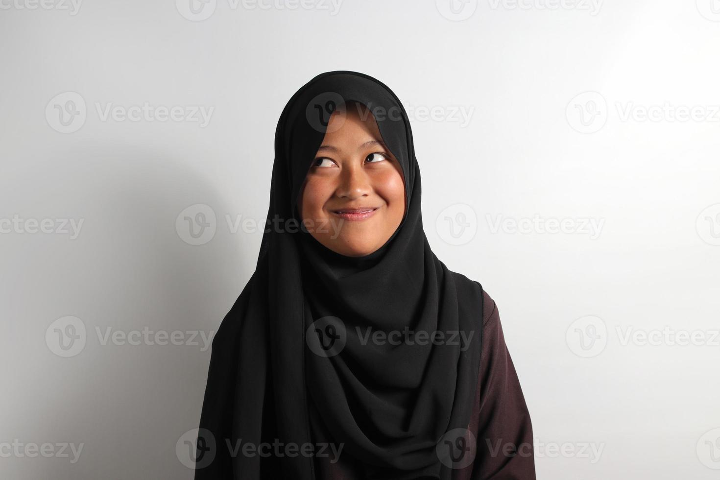 Young Asian girl wearing hijab thinking about creative and crazy ideas isolated on white background. photo