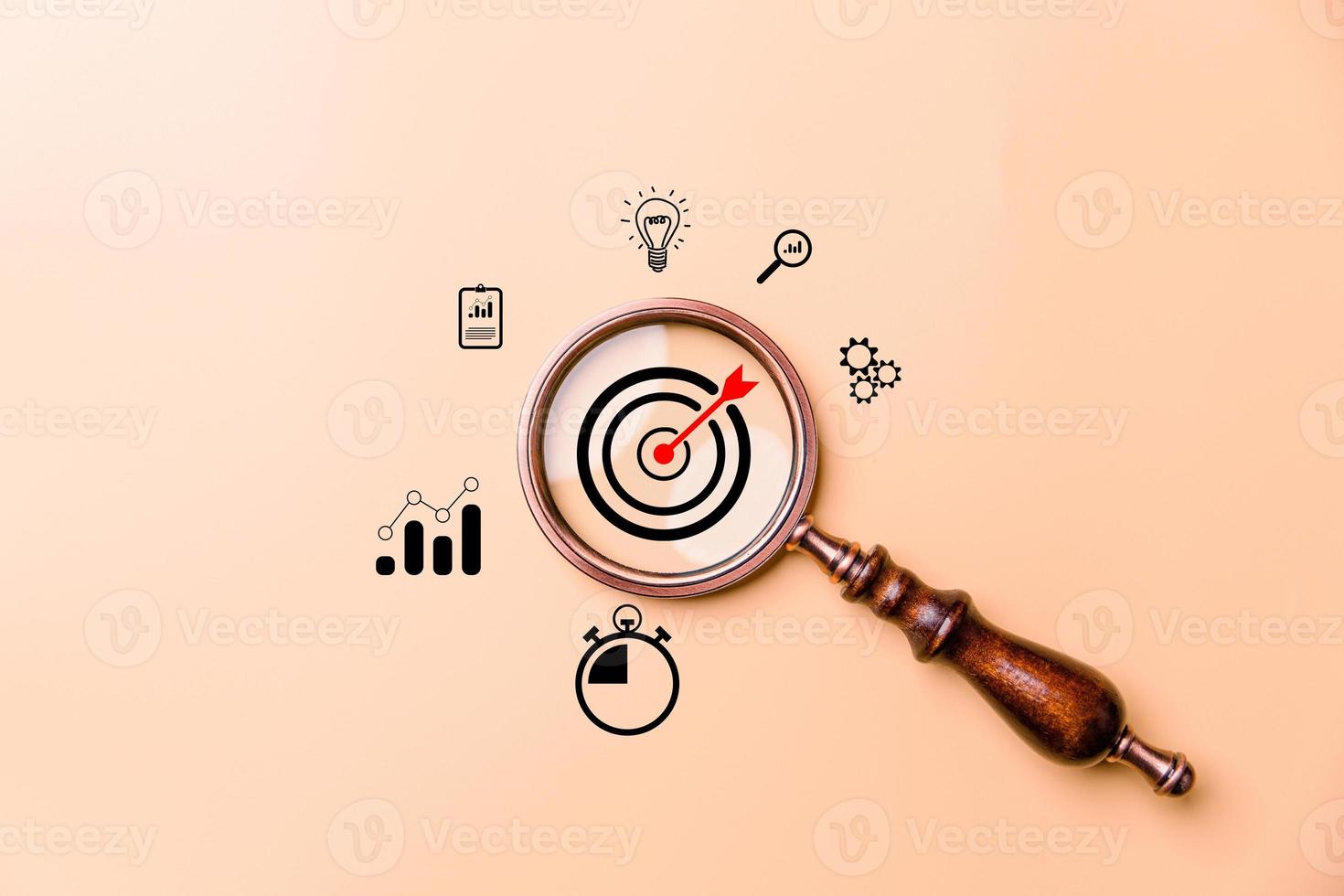 Hand holding target board inside vintage magnifying glass for focus business objective on orange background and copy space. Search, goal, strategy, success. successful marketing strategy goals photo