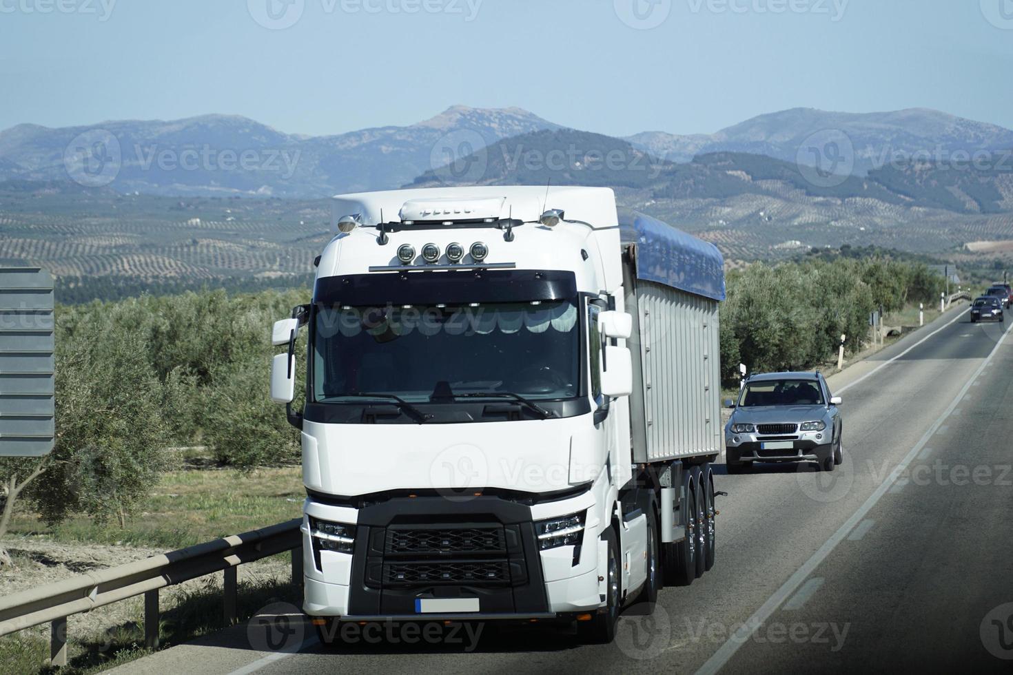 Truck on a Highway - Front View, Mountains on Second Plan photo