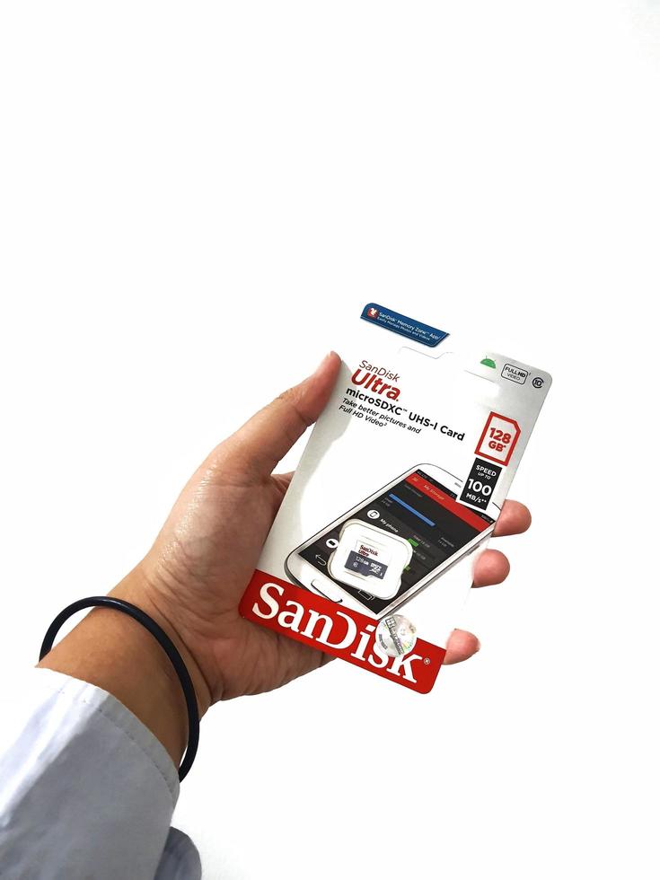 Jakarta, Indonesia in March 2023. Isolated white photo of a hand holding a brand new Sandisk Ultra micro sd memory card