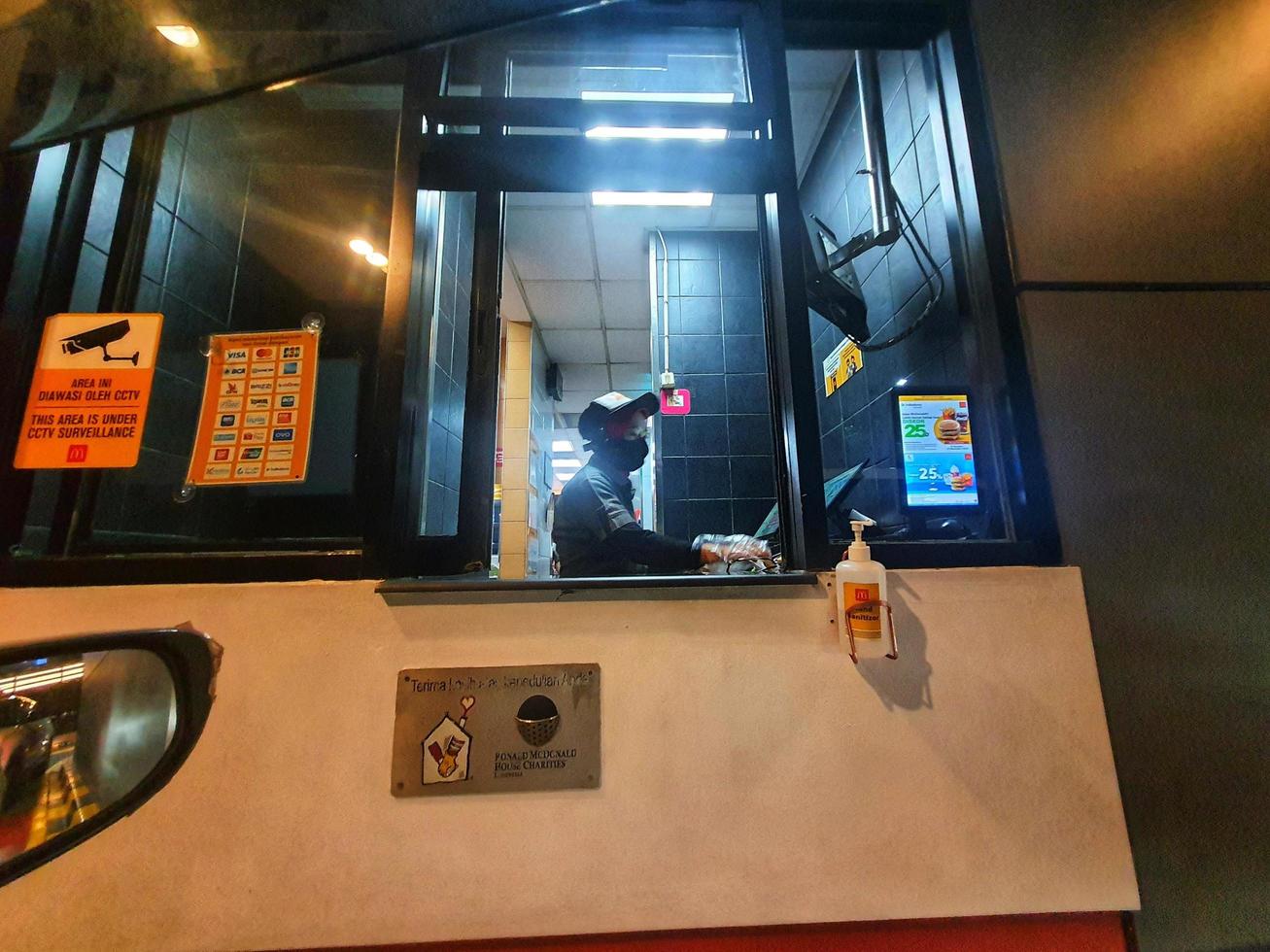 Bekasi, Indonesia in July 2022. A Mc Donald's employee is working at the drive thru service photo