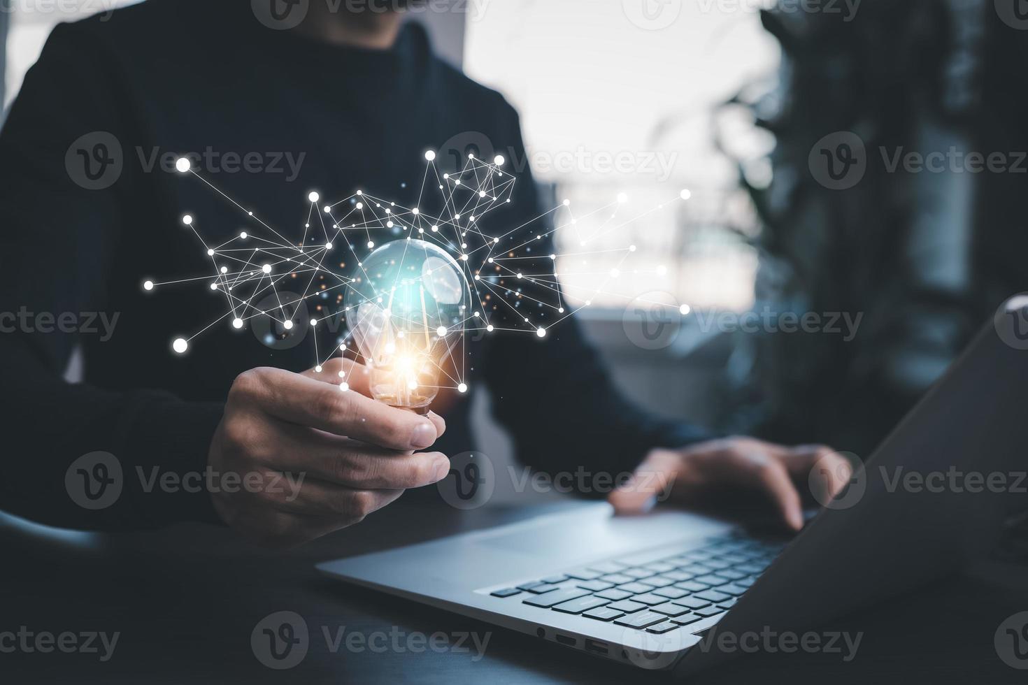 Man working and holding light bulb on the desk, Idea, innovation, and inspiration concept, creativity with hand draw light bulbs that shine glitter, new ideas with innovative technology and creativity photo
