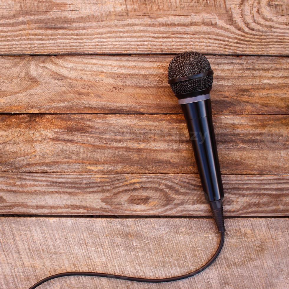 Microphone on wooden background. Toned image. photo