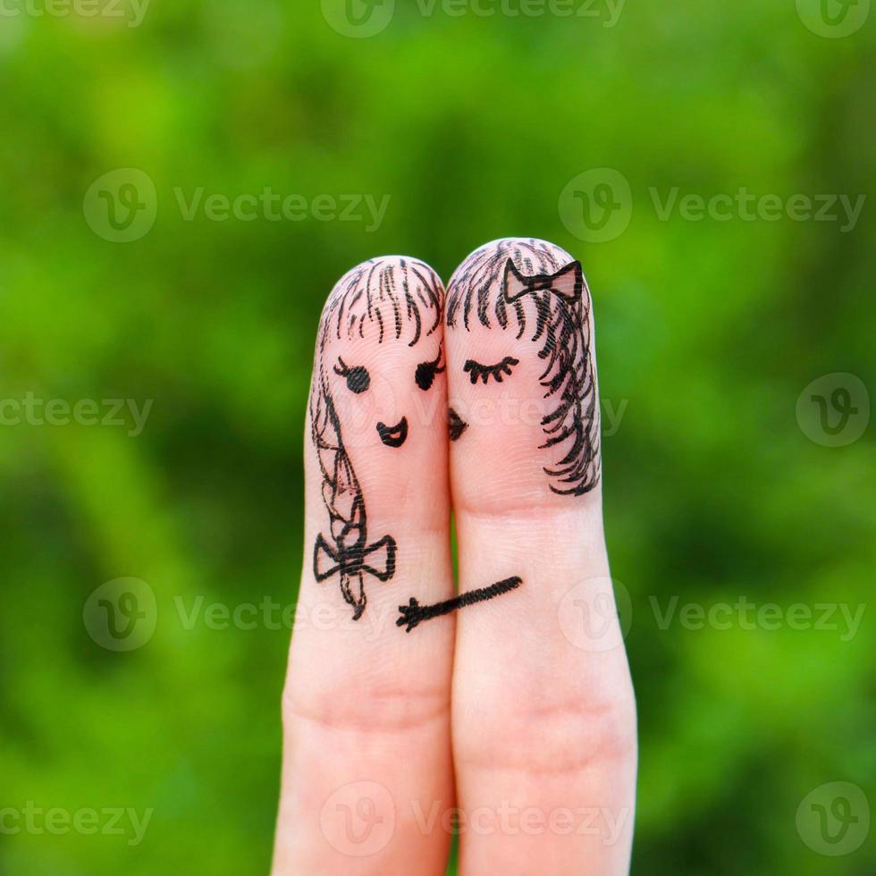 dedo Arte de dos mujer. mujer es besos su Novia en el mejilla. foto