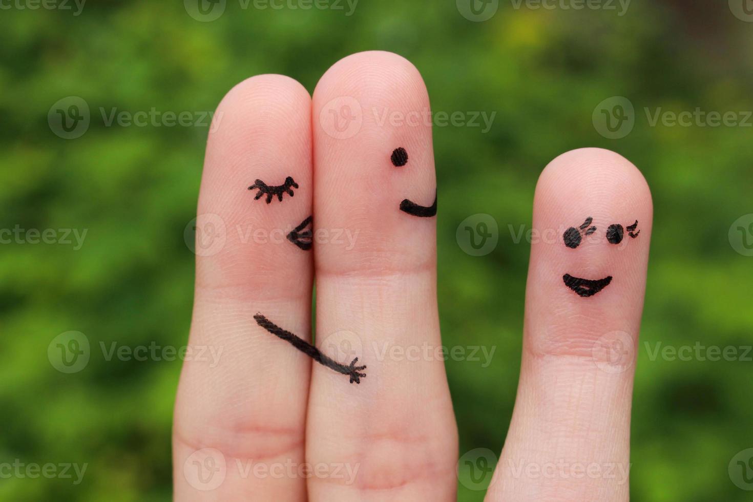 Finger art of a couple. Woman hugs and kisses the man, and he's flirting with another woman. The concept is not shared love. photo