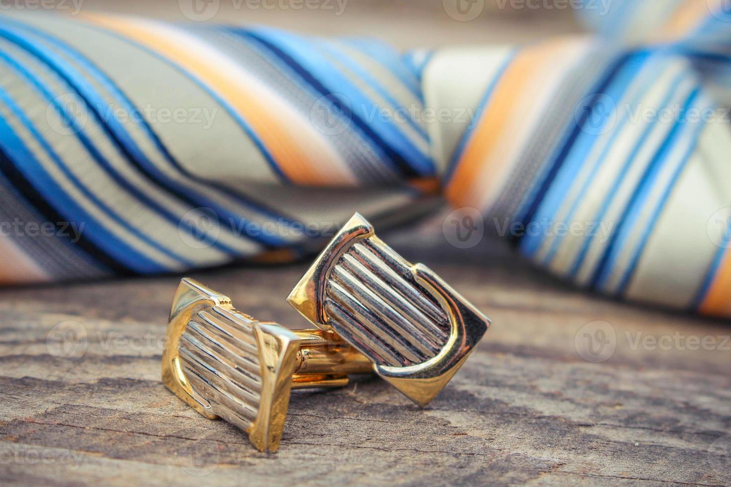 Tie, cufflinks and watches on the old wood background photo