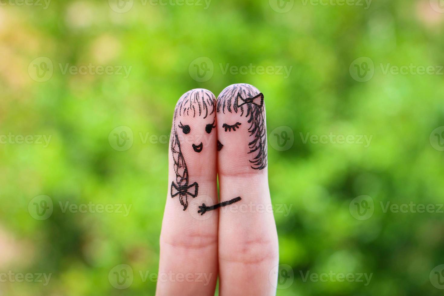 woman is kissing his girlfriend on the cheek photo