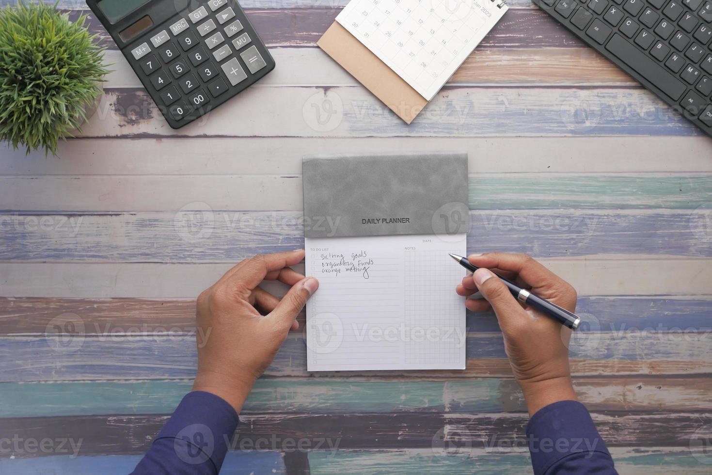 men hand writing on a weekly planner photo