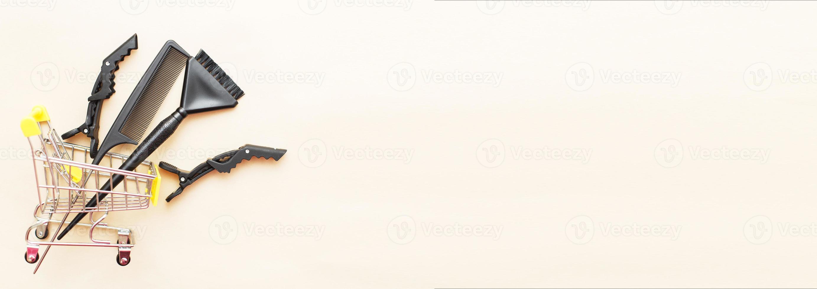 various hairdressing tools with shopping cart on a beige background. beauty salon concept photo