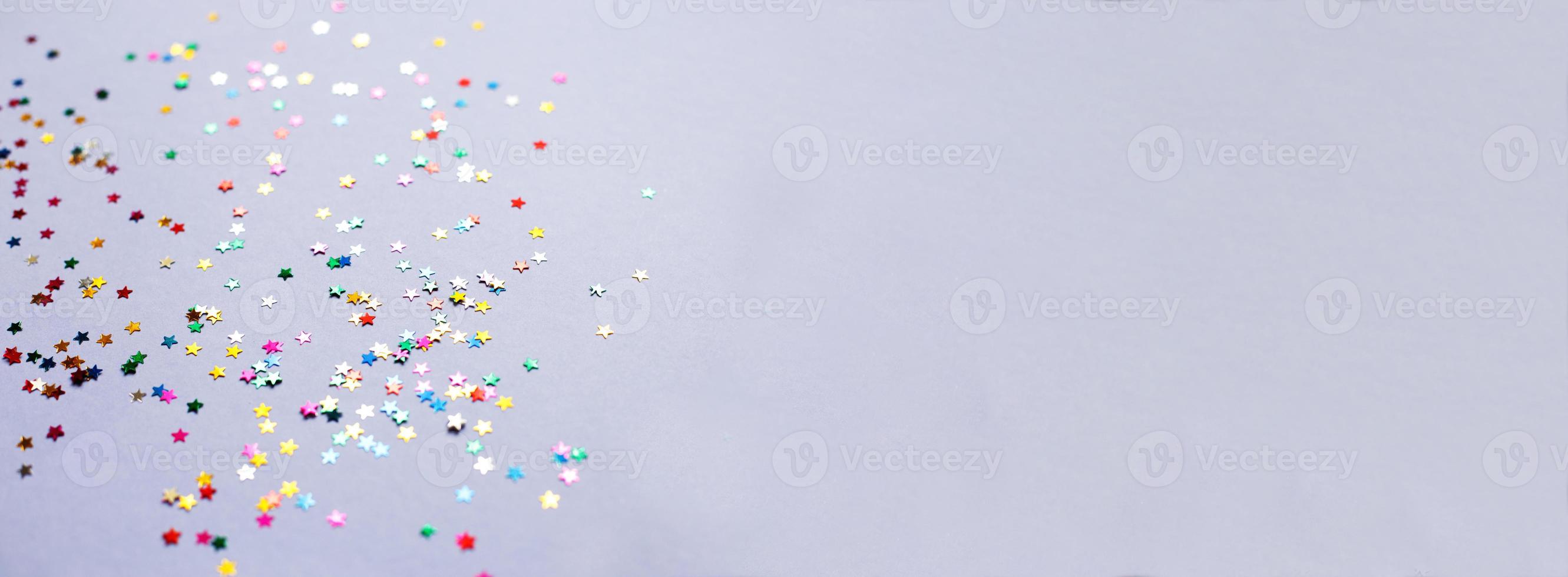 multicolor sparkles on a purple background. Festive backdrop for your projects. photo