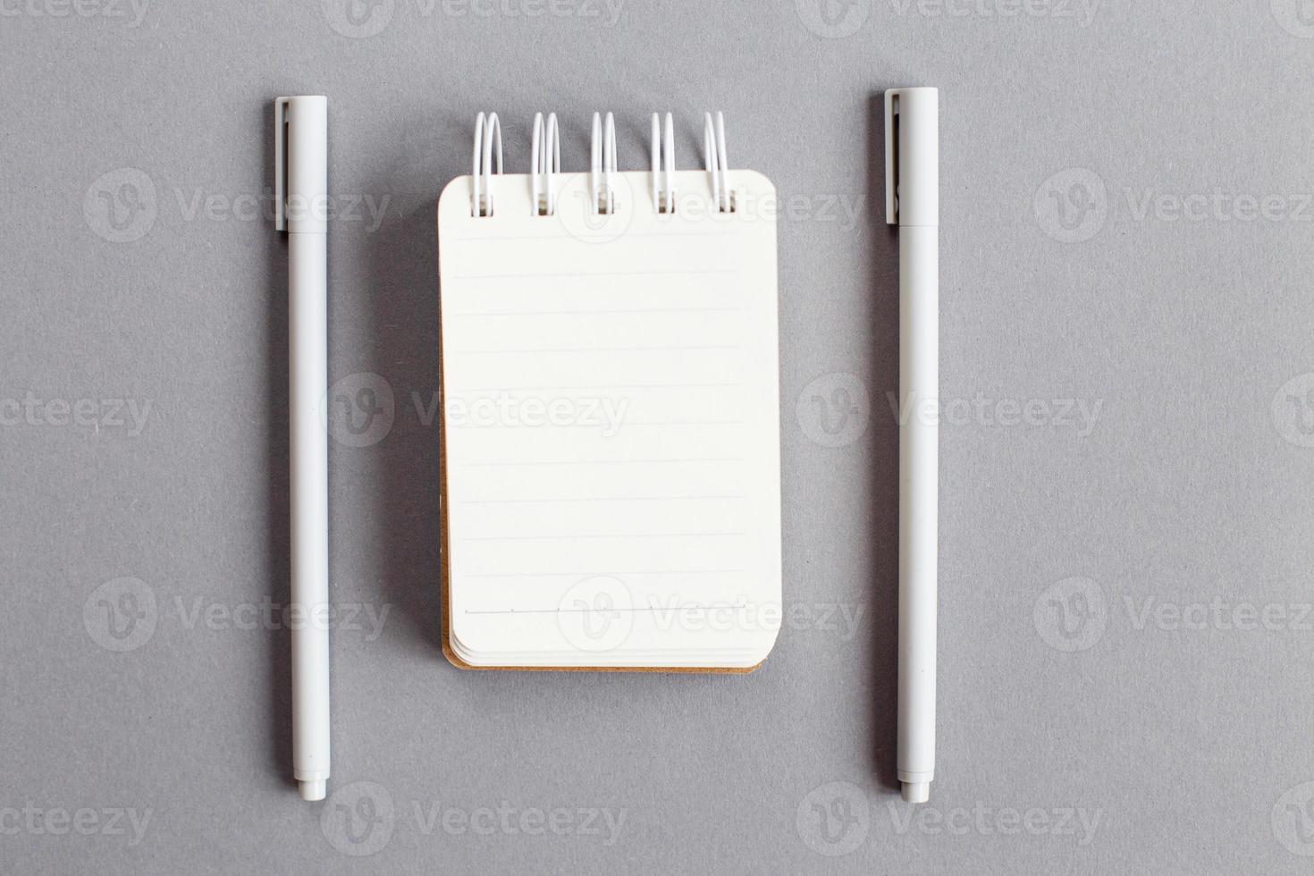 Top view of blank note paper with pen on gray background photo