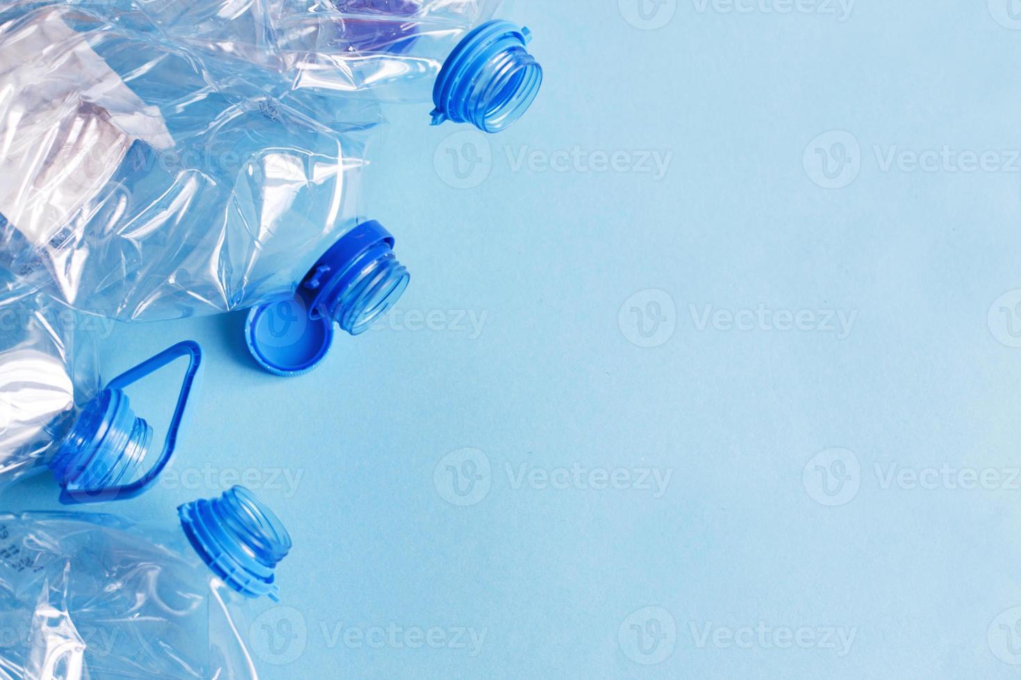 a lot of plastic empty rumpled used bottles on a blue background. waste and pollution concept photo