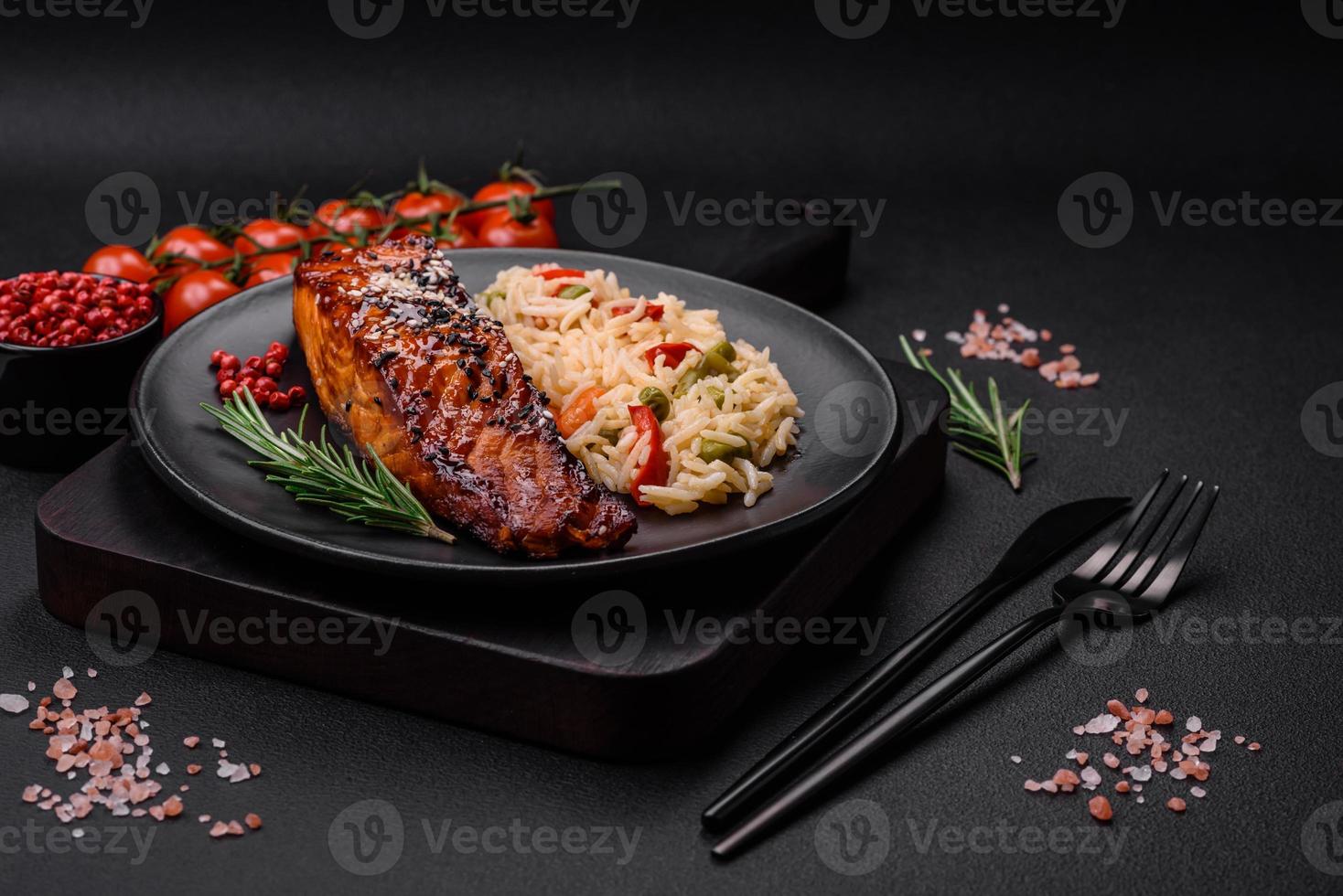 Delicious red salmon fish grilled with sauce and sesame seeds with rice and vegetables photo