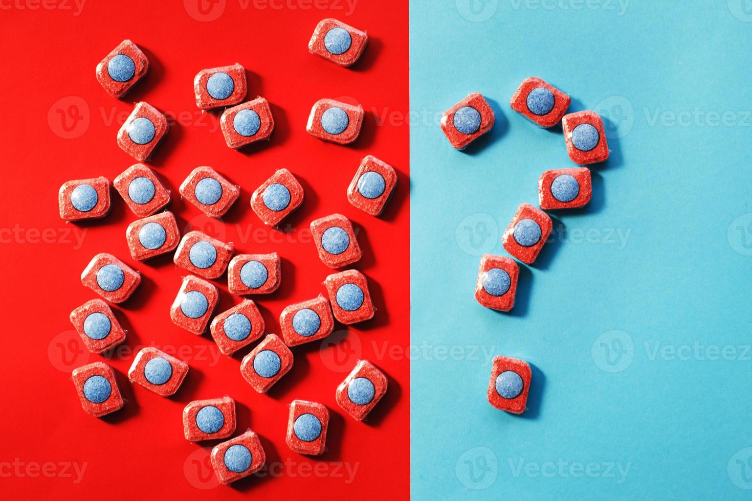 capsules for kitchen dishwashers and a question mark on a blue and red background. flat lay. photo