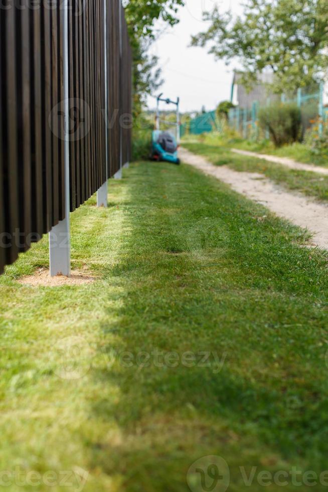 a man mows a lawn with a lawn mower photo