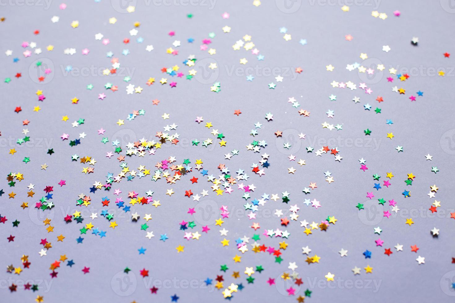 multicolor sparkles on a purple background. Festive backdrop for your projects. photo