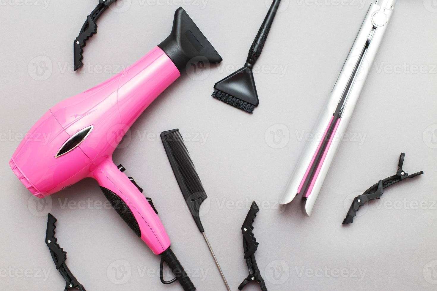 various hairdressing tools like hair dryer, comb on a gray background. beauty salon concept photo
