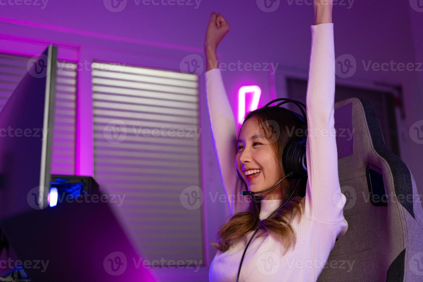 Asian gamer playing online video game winning excited on PC with lighting effect, broadcast streaming live at home. Gamer and E-Sport online gaming technology Championship tournament photo