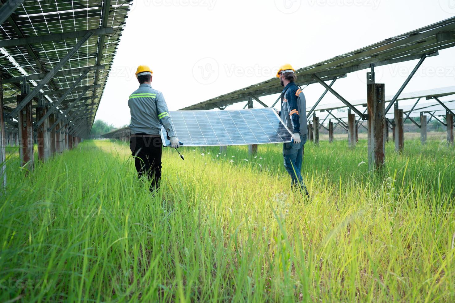 Engineering and technician unloading repaired solar panels to be installed on the rows of solar cells lined up on hundreds of acres of grass photo