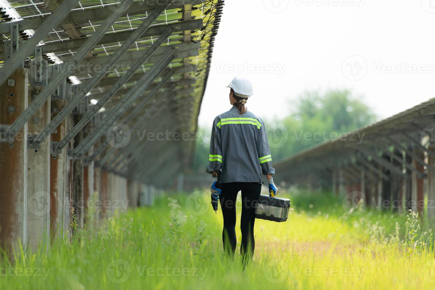 Technicians are walking to inspect solar panels according to the daily inspection schedule. To keep repairing and checking the efficiency of solar cells photo