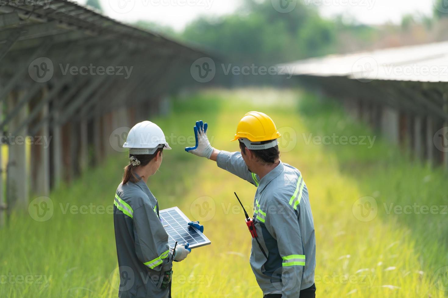 At hundreds of acres of grass with solar panels A team of electric power engineers is testing a prototype of a small solar panel installed on this field. photo