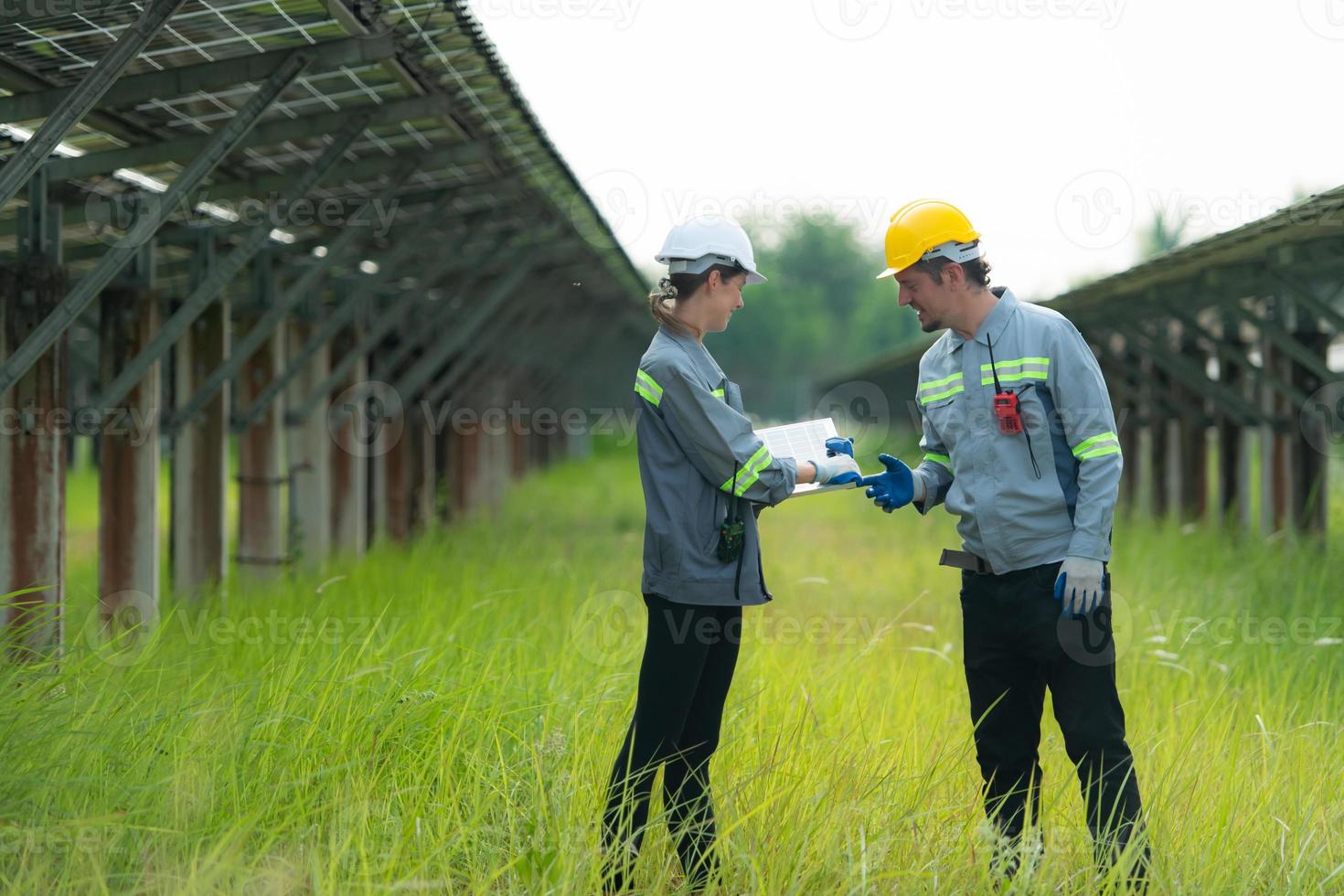 At hundreds of acres of grass with solar panels A team of electric power engineers is testing a prototype of a small solar panel installed on this field. photo
