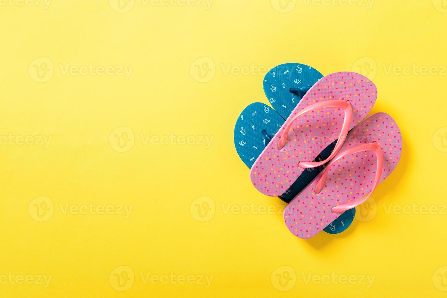 A lot of colored flip flops on yellowbackground. Top view with copy space photo