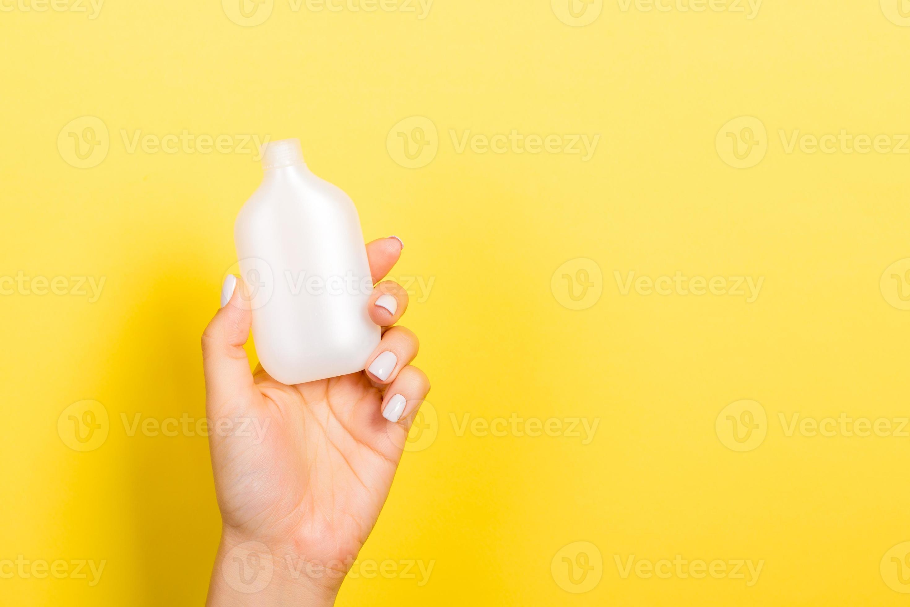 Female hand holding cream bottle of lotion isolated. Girl give tube