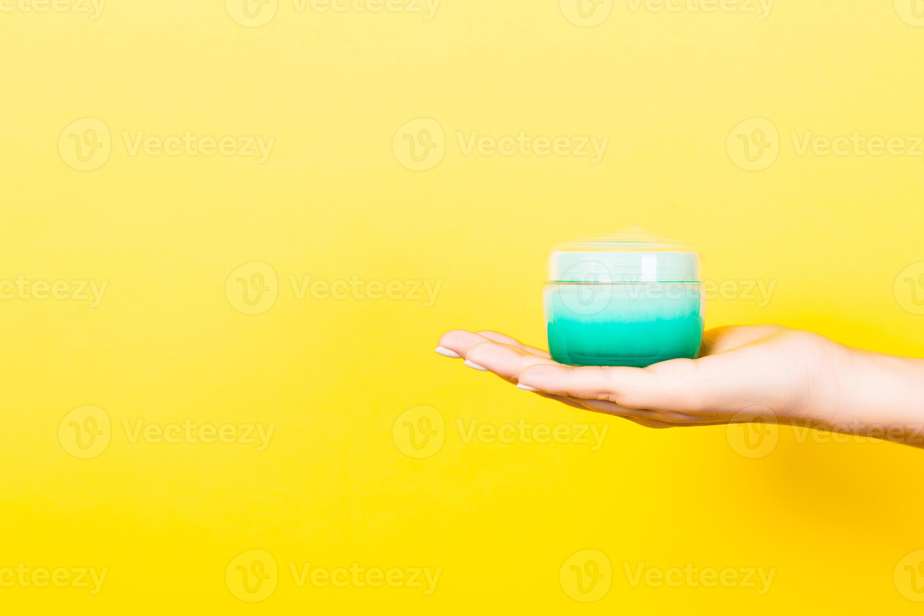 Female hand holding cream bottle of lotion isolated. Girl give jar