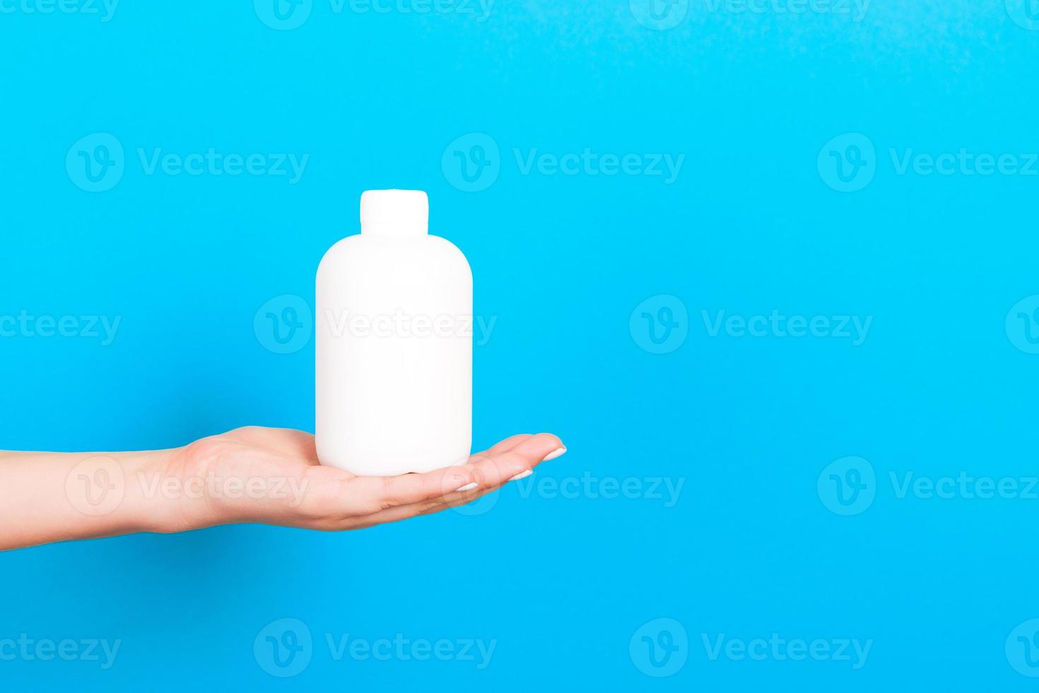 Female hand holding cream bottle of lotion isolated. Girl give tube