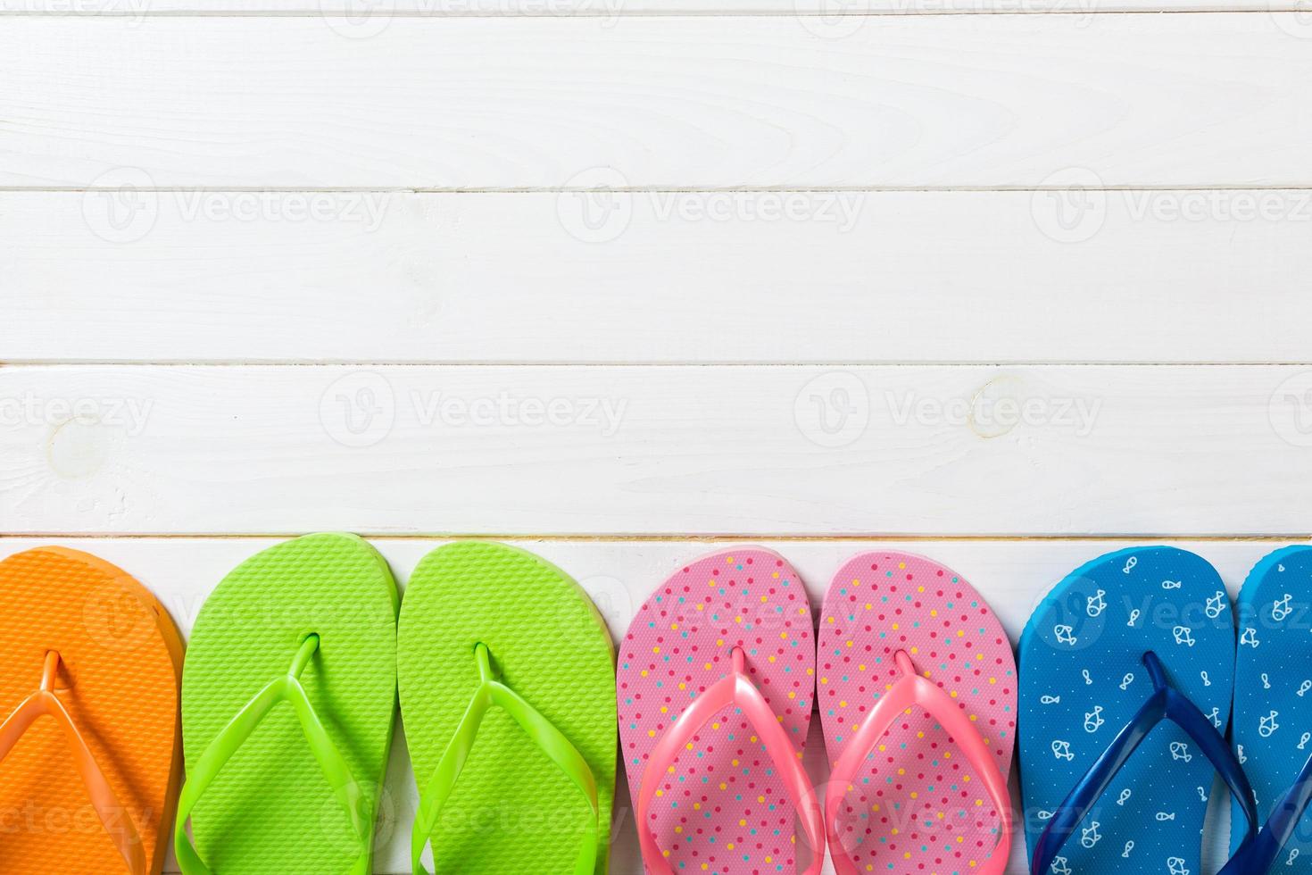 a lot of flip flop colored sandals, summer vacation on wooden background, copy space top view photo