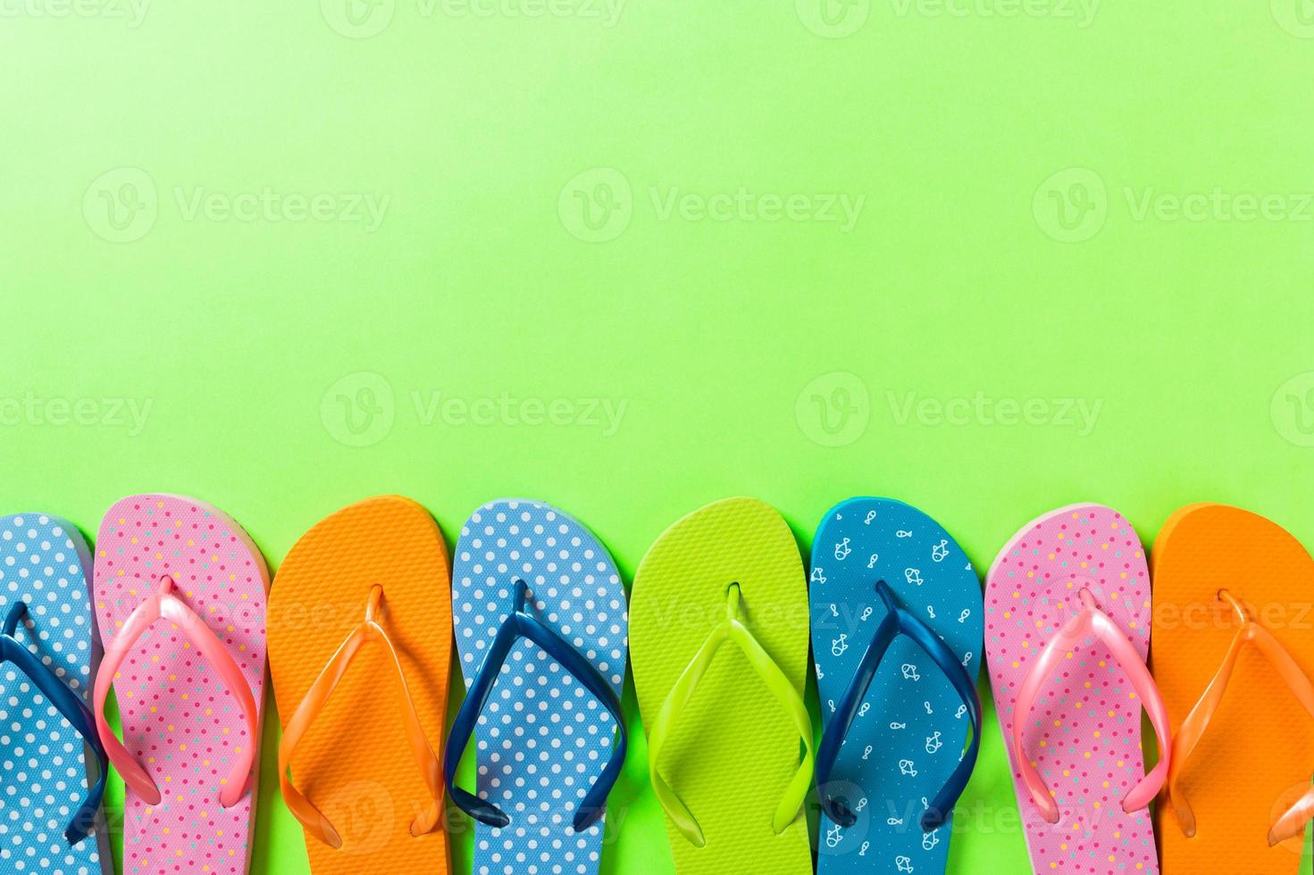 a lot of flip flop colored sandals, summer vacation on colored background, copy space top view photo