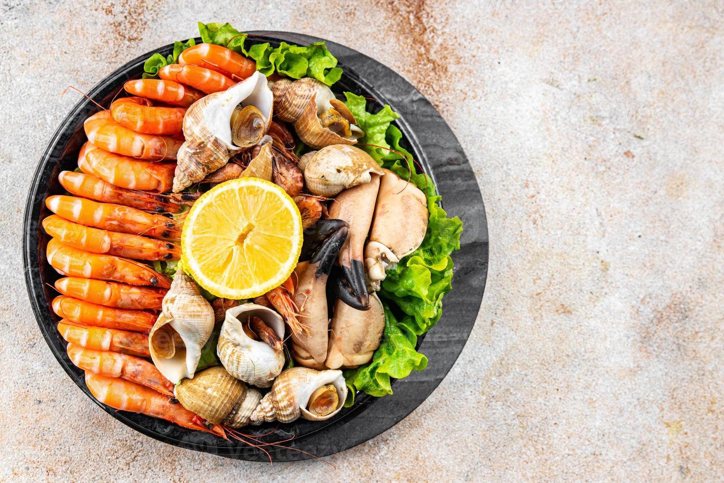 seafood platter Fruits de mer shrimp, crab claw, clam, rapan, trumpeter mollusk  meal food snack on the table copy space food background rustic top view photo