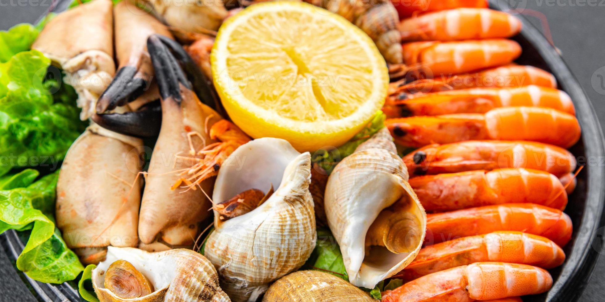 seafood platter Fruits de mer shrimp, crab claw, clam, rapan, trumpeter mollusk  meal food snack on the table copy space food background rustic top view photo