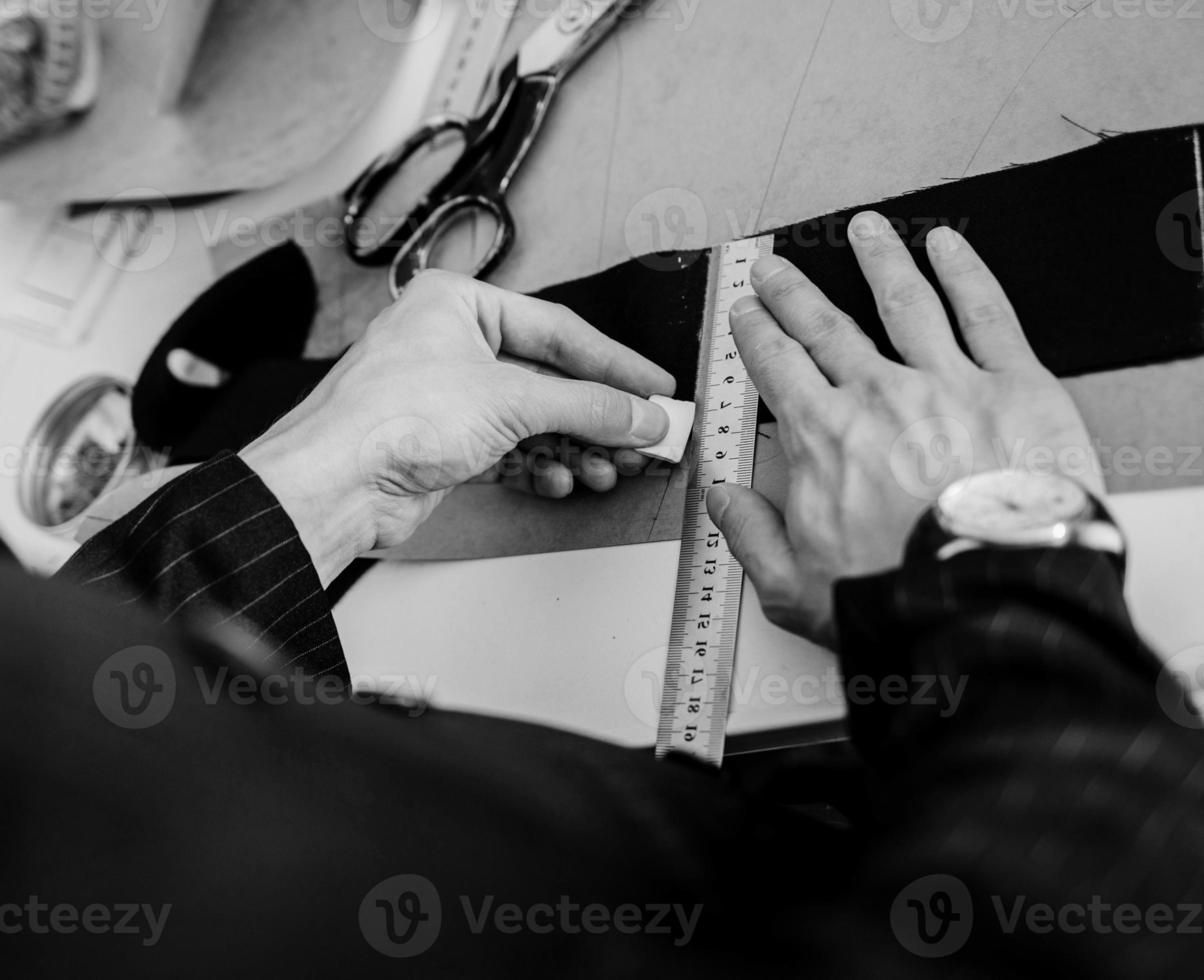 man seamstress makes pattern with chalk photo