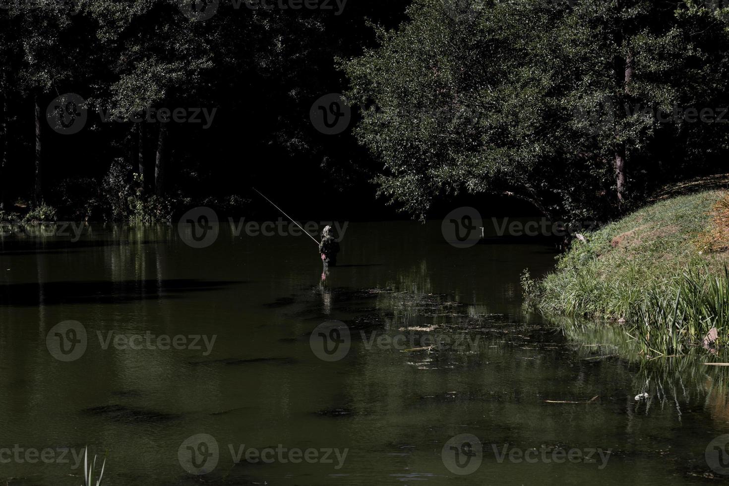 Man fishing in a river. photo