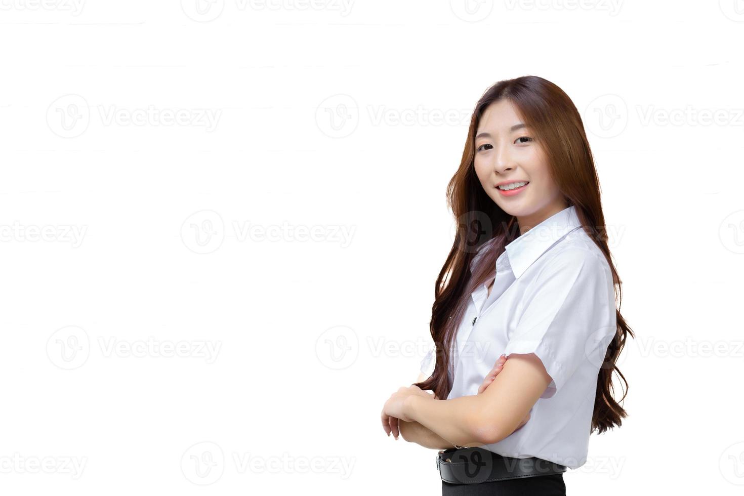 Portrait of adult Thai student. Cute Asian young girl student in uniform is smiling and looking at camera with her arms crossed confidently isolated on white background. photo