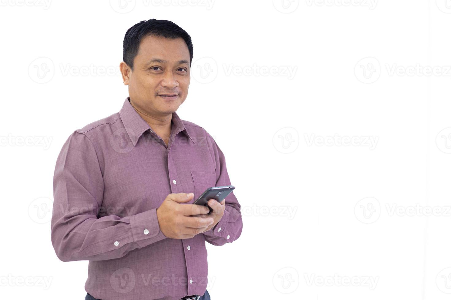 Asian business adult man is holding smartphone mobile phone in his hand and looking at camera isolated on white background. photo