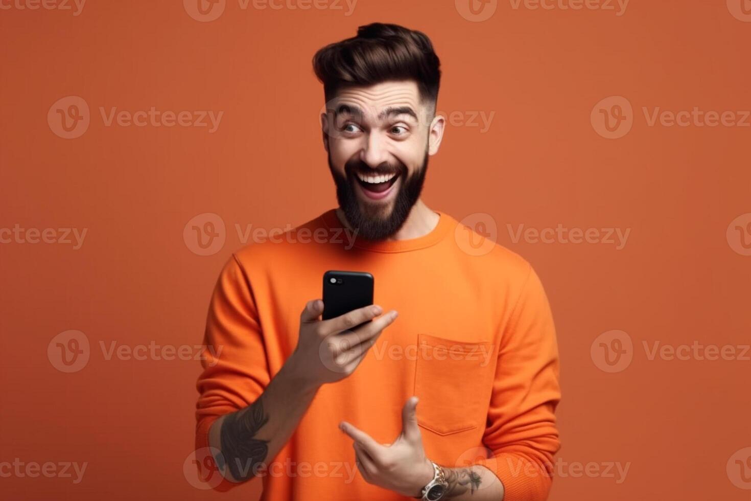 A man with a surprised expression is holding a phone in his hands. photo