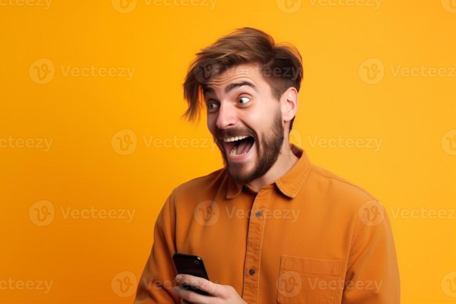 A man with a surprised expression is holding a phone in his hands. photo