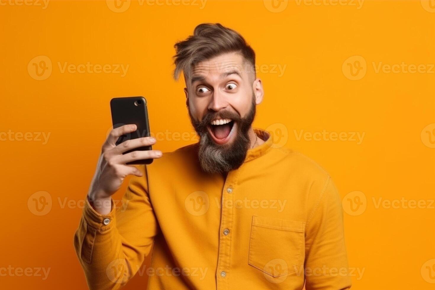 A man with a surprised expression is holding a phone in his hands. photo